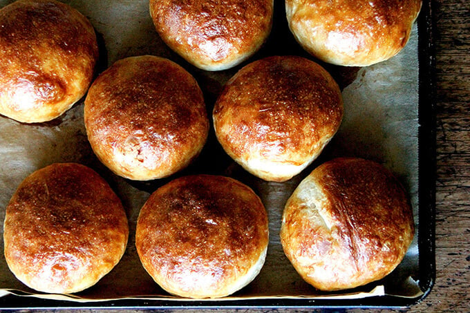 A sheet pan with freshly baked brioche buns. 