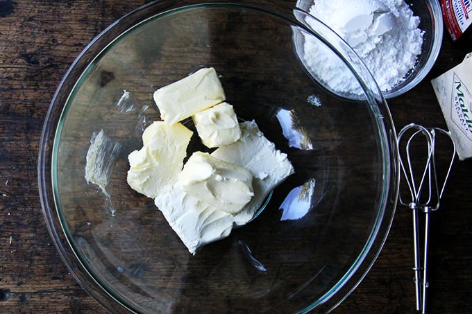 A bowl filled with ingredients for cream cheese frosting. 