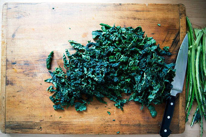 A board with chopped kale. 