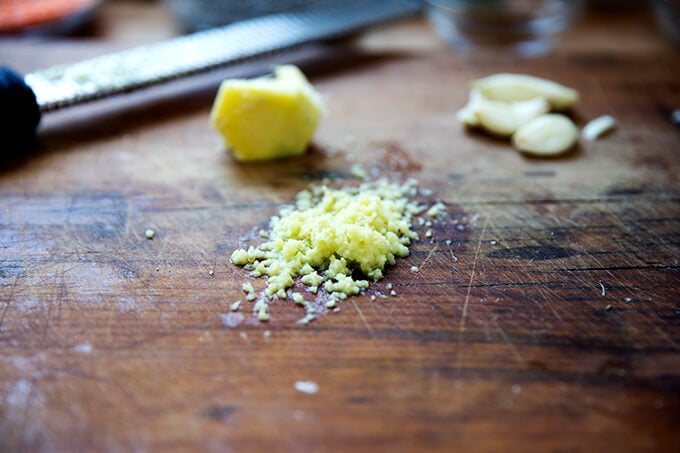 finely grated ginger with a microplane on a board