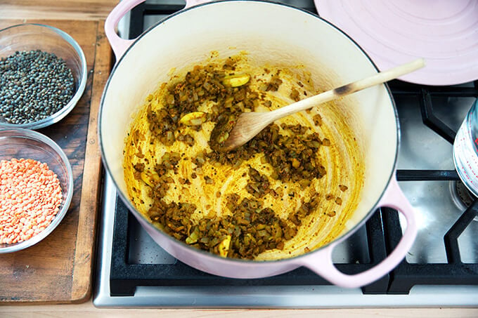 adding the curry spices to the onions sauteeing in a dutch oven stovetop