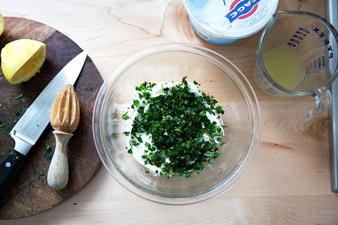 adding the parsley to the yogurt sauce