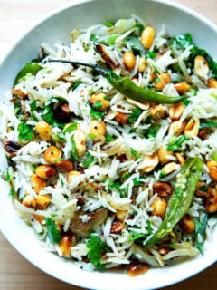 A bowl of Indian fried rice with peanuts and chilies.