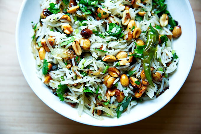 A bowl of Indian fried rice with peanuts and chilies.