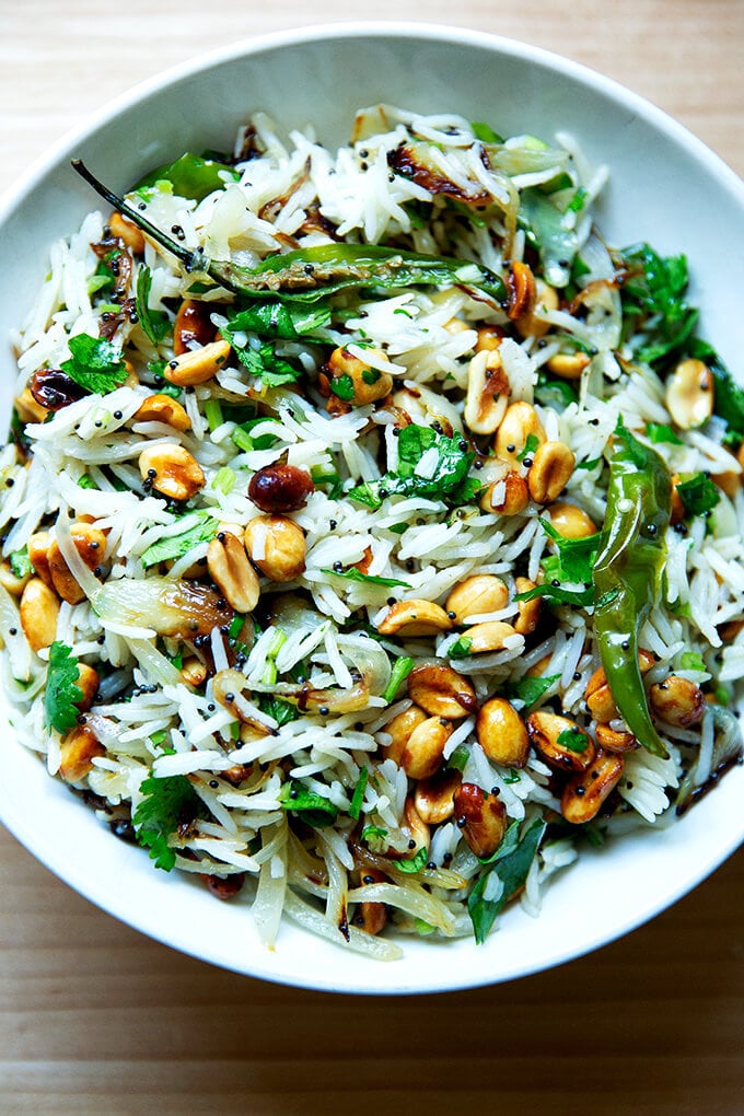 A bowl of Indian fried rice with peanuts and chilies.