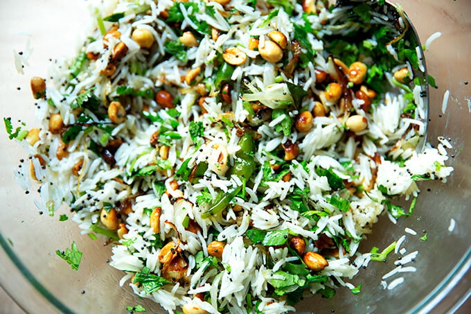 A bowl of Indian fried rice with peanuts and chilies.