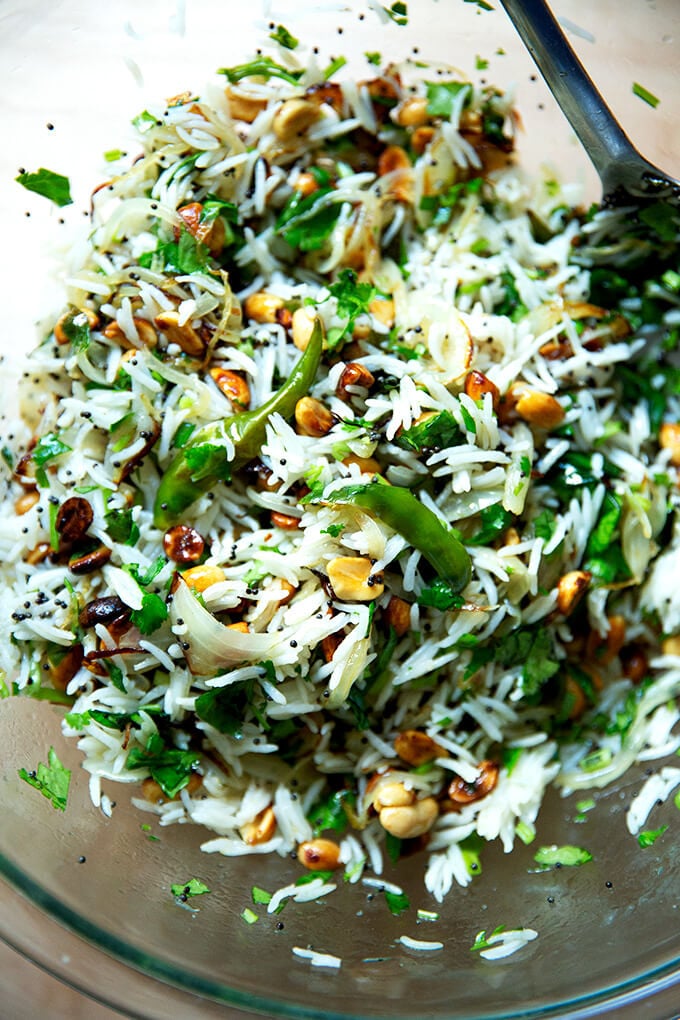 A bowl of Indian fried rice with peanuts and chilies.