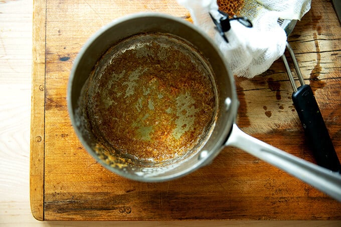 A pot with a layer of butter solids at the bottom.