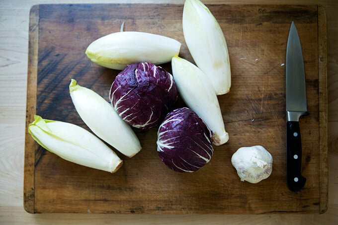 Belgian Endive, radicchio, and garlic on a cutting board.