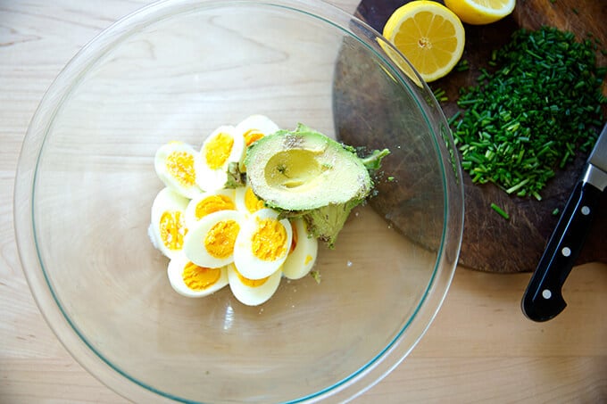 A bowl of half a dozen Instant Pot hard-boiled eggs, 1 avocado, and salt.