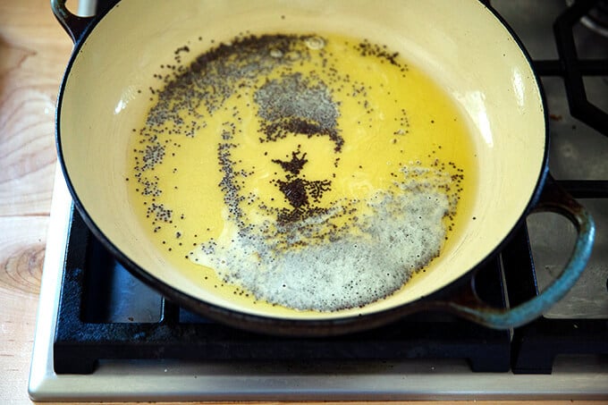 A braiser pan with ghee and mustard seed.