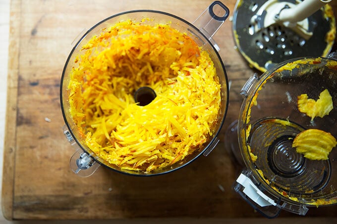 Food processor filled with shredded beets and carrots