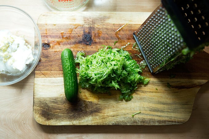 A cutting board with grated cucumber.