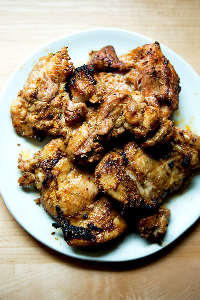 Smoky grilled chicken resting on a platter.