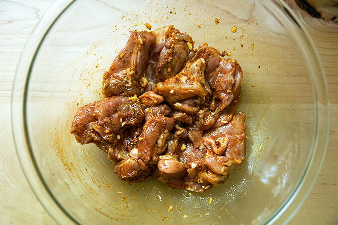 chicken thighs marinating in salt, smoked paprika, toasted cumin, coriander, garlic, and oil