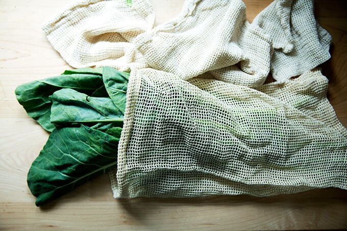 A reusable produce bag filled with collard greens.