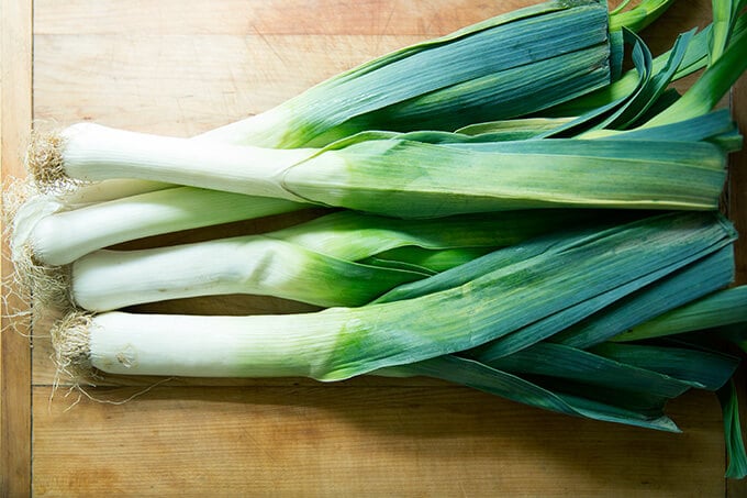 Whole leeks on a cutting board. 