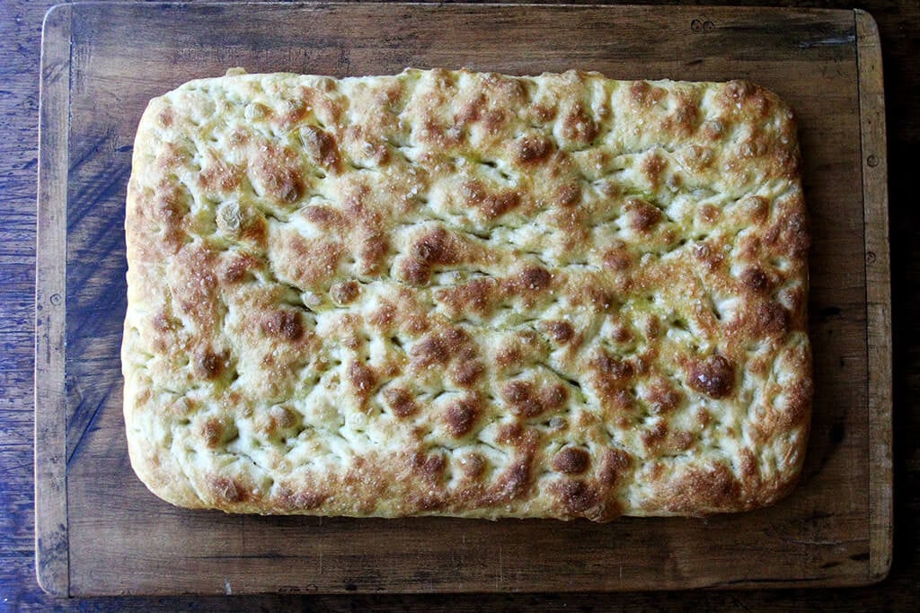 A cutting board with baked focaccia.