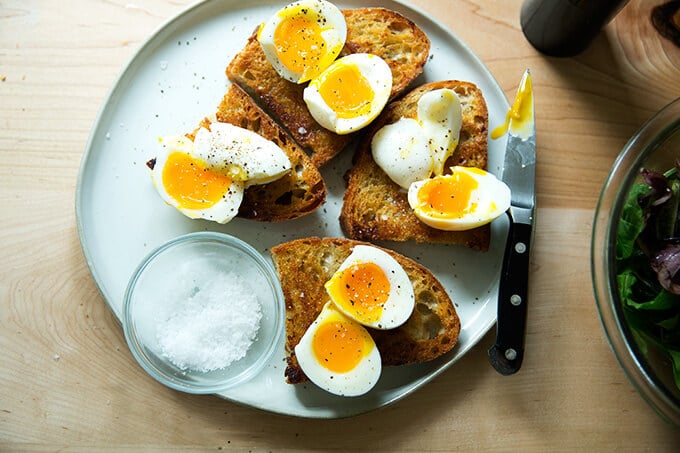 A plate of cut eggs on vinaigrette toast, seasoned.