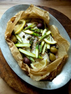 A sizzle pan with an opened fish en papillote.
