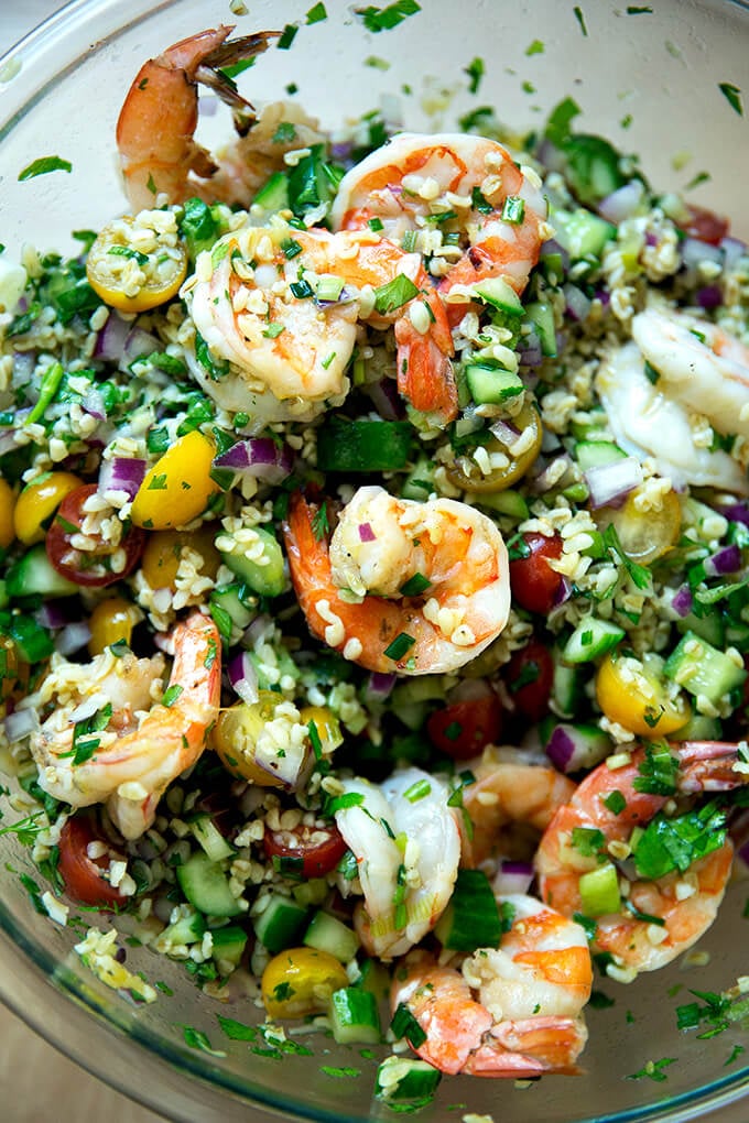 A bowl of tabbouleh with cilantro, lime, and grilled shrimp.