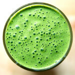 An overhead shot of a green smoothie with spinach, almond butter, and dates.
