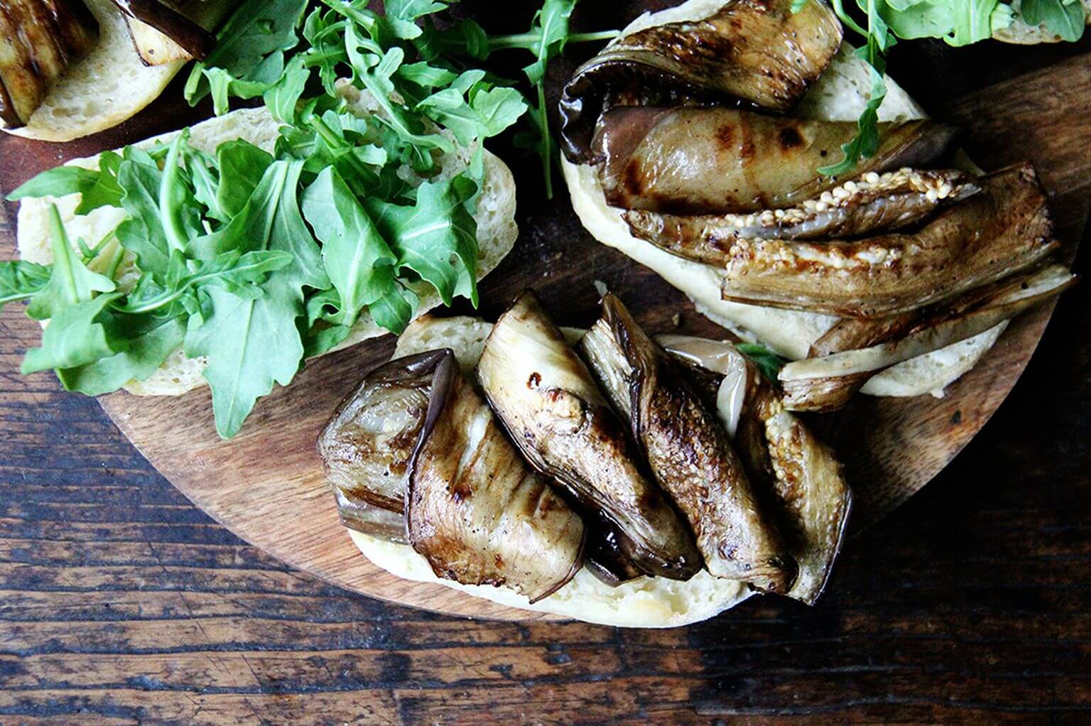 an open eggplant and arugula sandwich