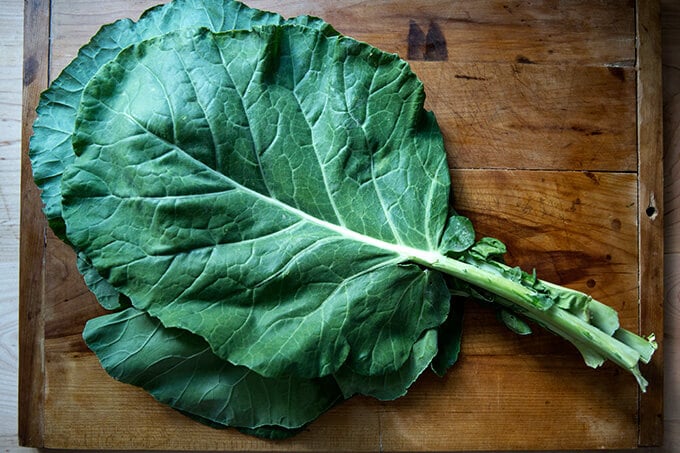 A bunch of collard greens on a board.