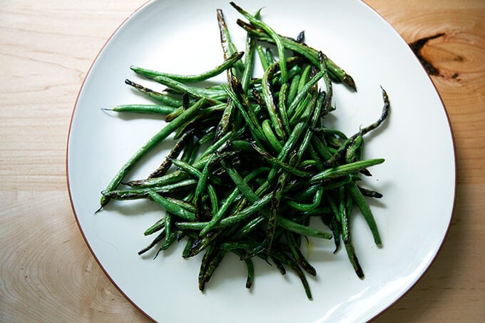 A platter of blistered green beans. 