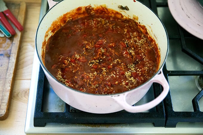 A large pot of vegetables and bulgur cooking stovetop.