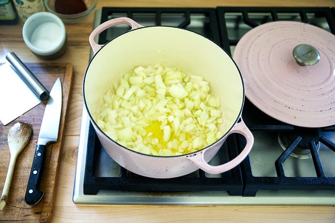 A large pot filled with onions sautéing in olive oil.