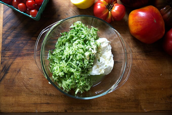 Grated cucumber and yogurt in a large bowl.