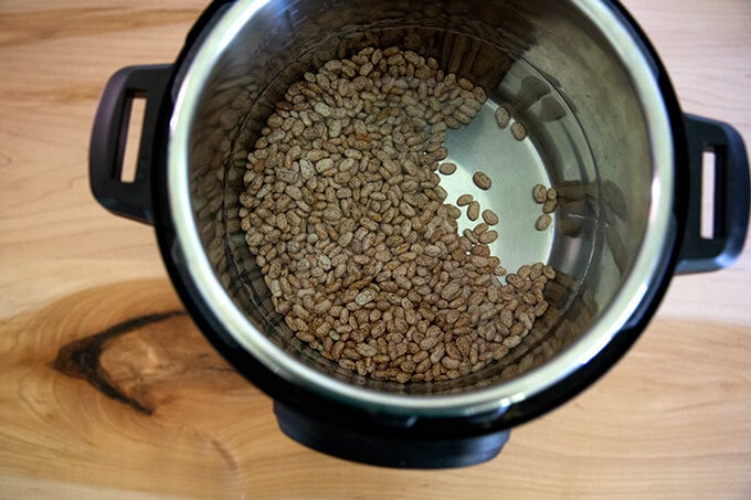 Dried pinto beans in the Instant Pot covered with water.