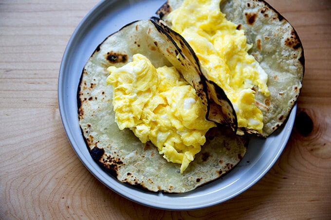 Two flour tortillas filled with scrambled eggs.