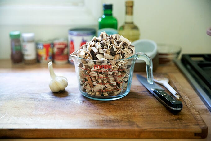 A heap of chopped mushrooms in a measuring cup.