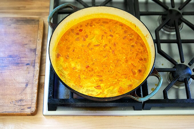 Curry sauce simmering in a large sauté pan