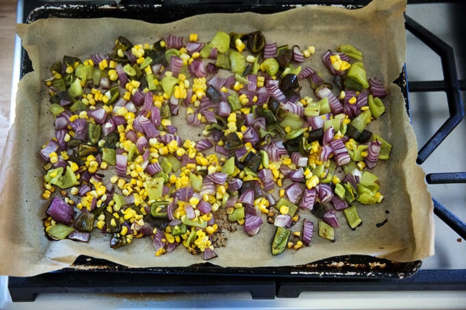 Roasted vegetables on a sheet pan lined with parchment paper.