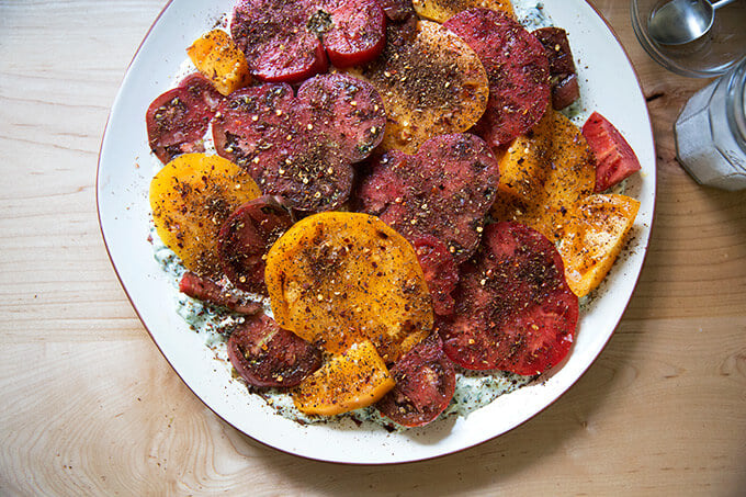 Israeli-spiced tomatoes on a platter of cucumber-yogurt sauce.