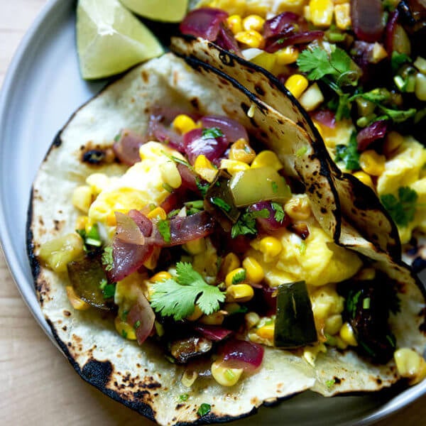 A plate of an egg taco topped with roasted vegetable salsa.