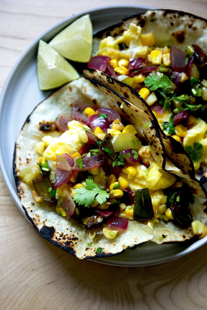 A plate of an egg taco topped with roasted vegetable salsa.