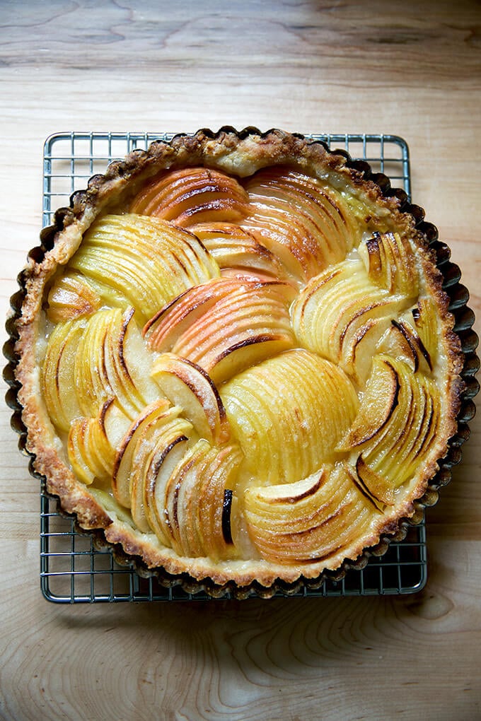 A French apple tart just baked on a cooling rack.