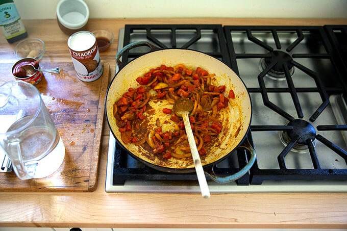 A board with sautéed onions, spices and tomatoes.