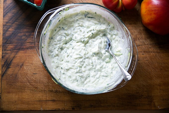 Cucumber yogurt sauce stirred together in a large bowl.