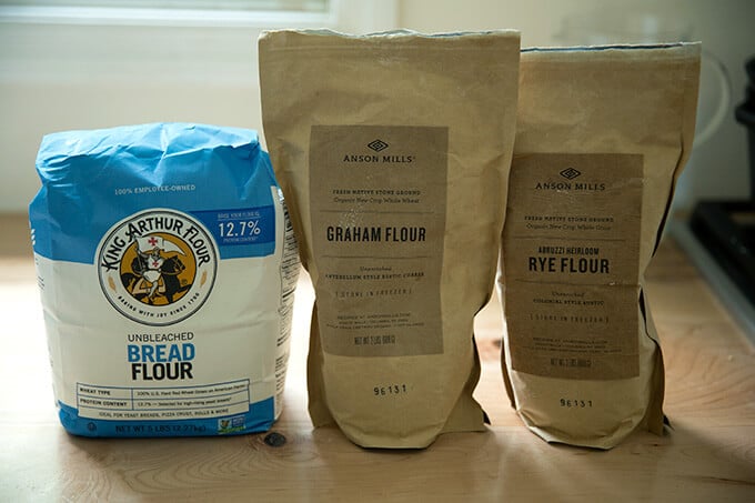 Tre farine su un piano di lavoro: King Arthur Flour bread flour, Anson Mills Graham Flour, Anson Mills Rye flour.