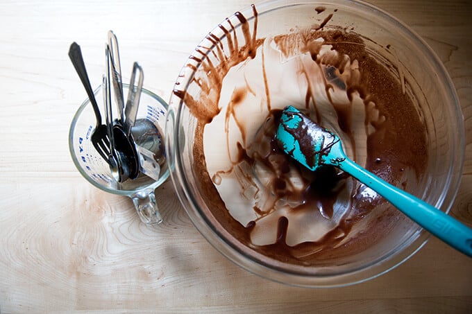 Dirty dishes: a large bowl smeared with chocolate batter and a liquid measure filled with dirty utensils.