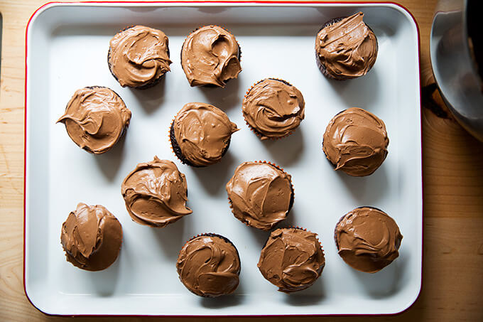 A tray filled with chocolate cupcakes frosted. 