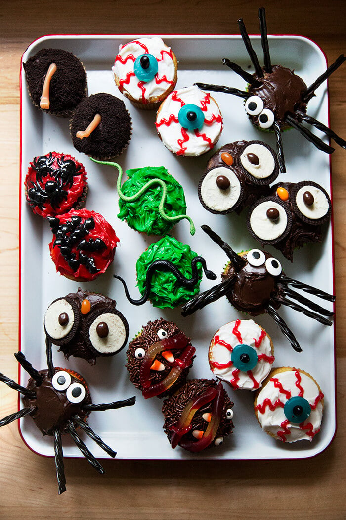 A tray filled with festively decorated Halloween cupcakes. 