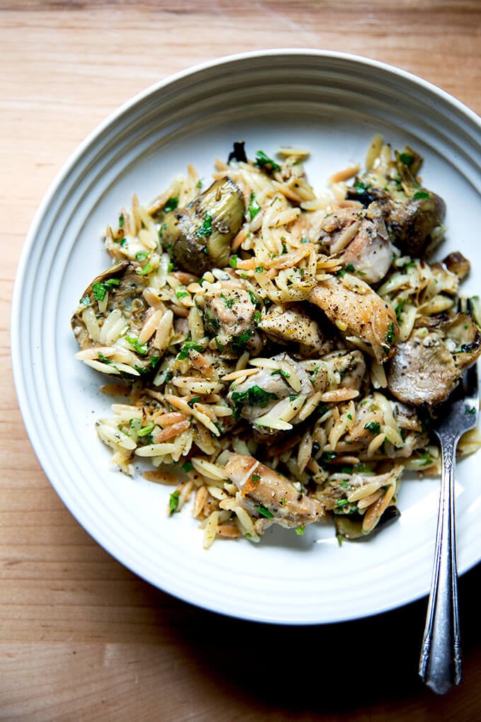 A plate of one-pan lemon chicken orzo with artichoke hearts.