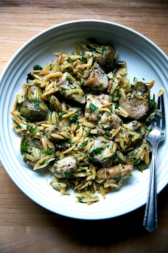 A plate of one-pan lemon chicken orzo with artichoke hearts.
