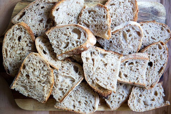 A board loaded with slices of high hydration sourdough bread.